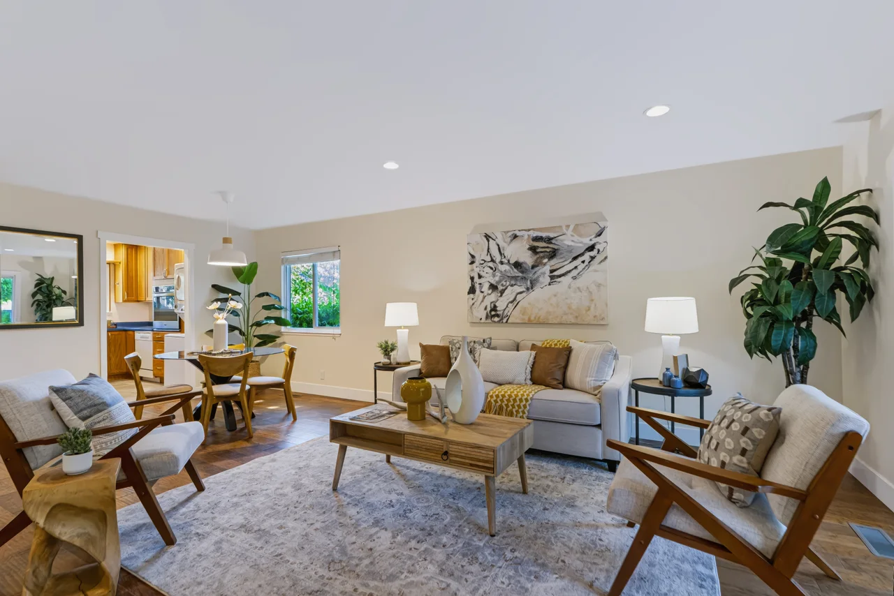 Bright living and dining room with neutral furniture and indoor plants