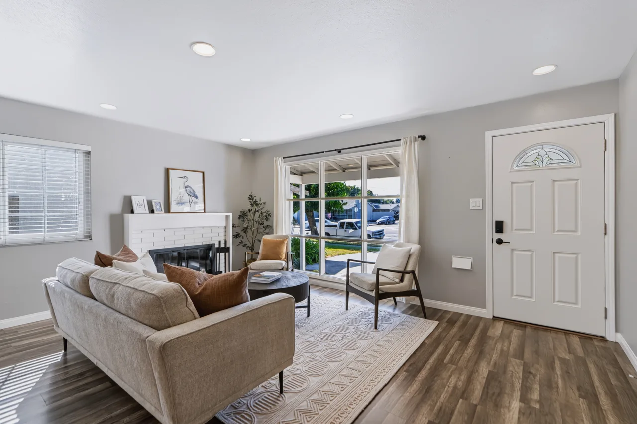 Living room with fireplace, front entry, and sliding doors to the garden