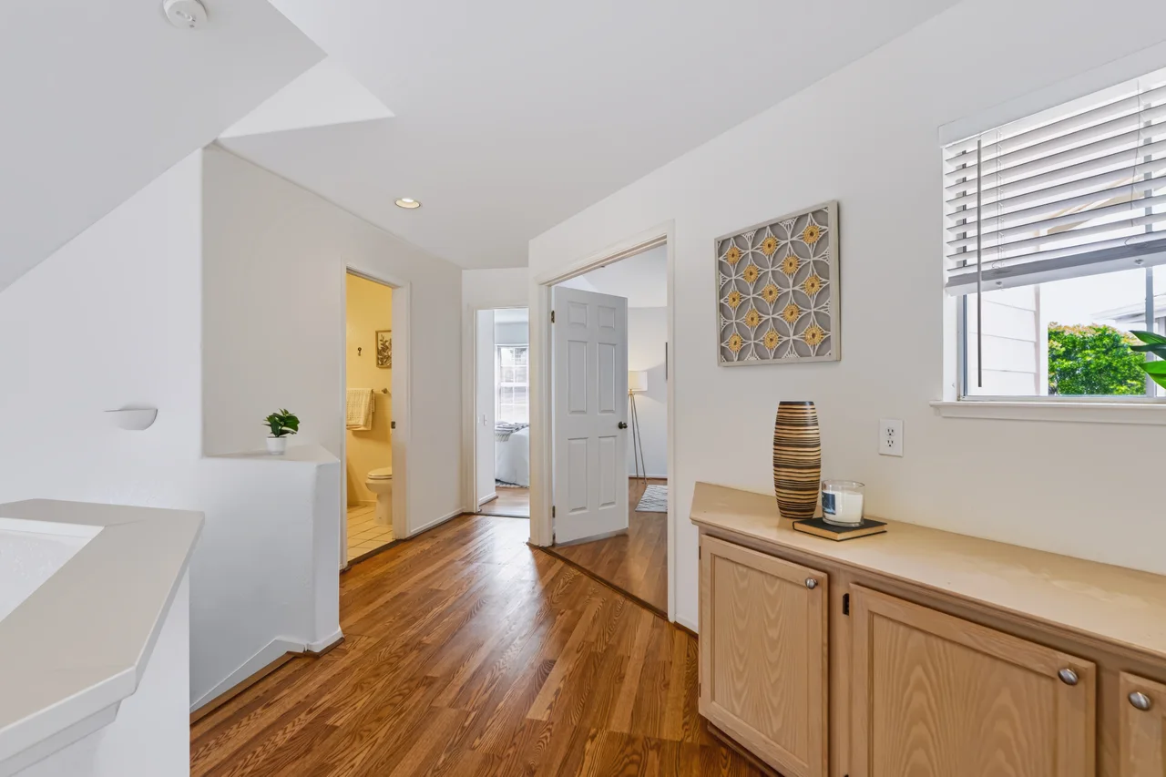 Open hallway with wood floors and a built-in wood cabinet