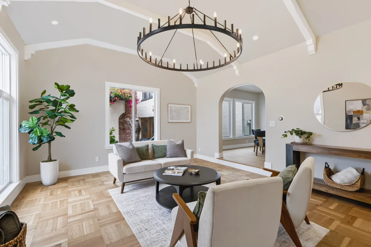 Dining room with a round table, upholstered chairs, and a chandelier