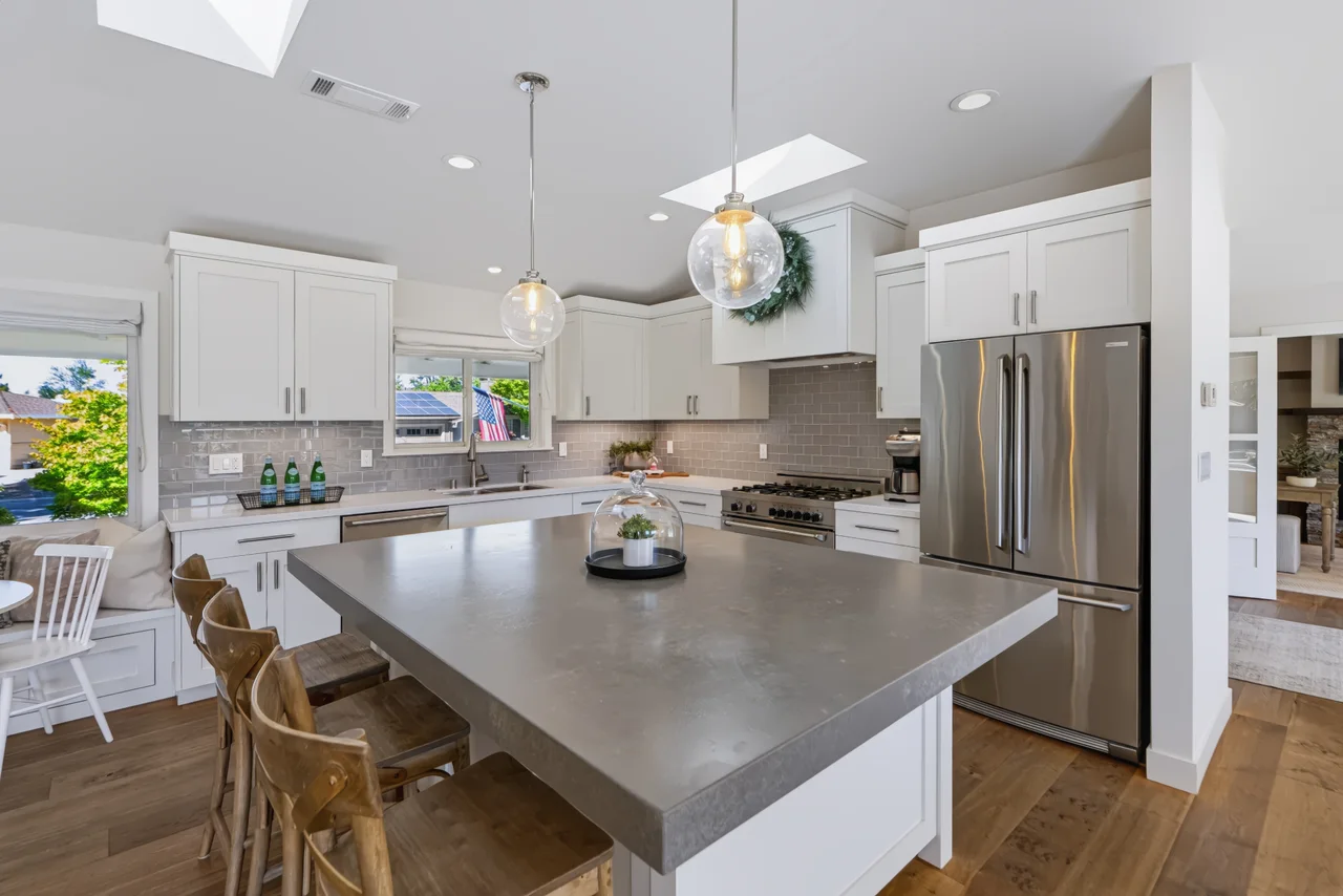 Kitchen island opening to a dining area and living room