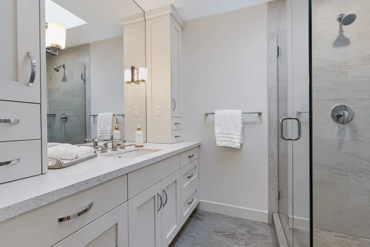 Bathroom with a double vanity and a glass-enclosed shower